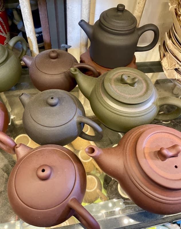 Assorted clay teapots in red, brown and green clay