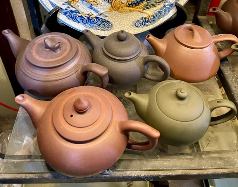 Unglazed clay teapots on a workshop shelf