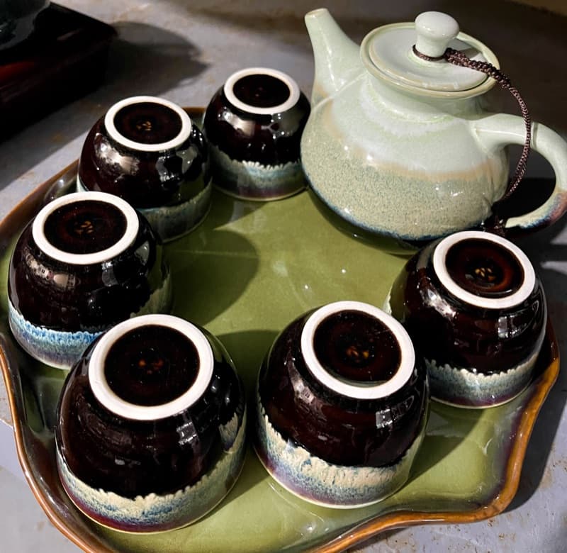 Tenmoku cups with celadon teapot on a leaf-shaped tray